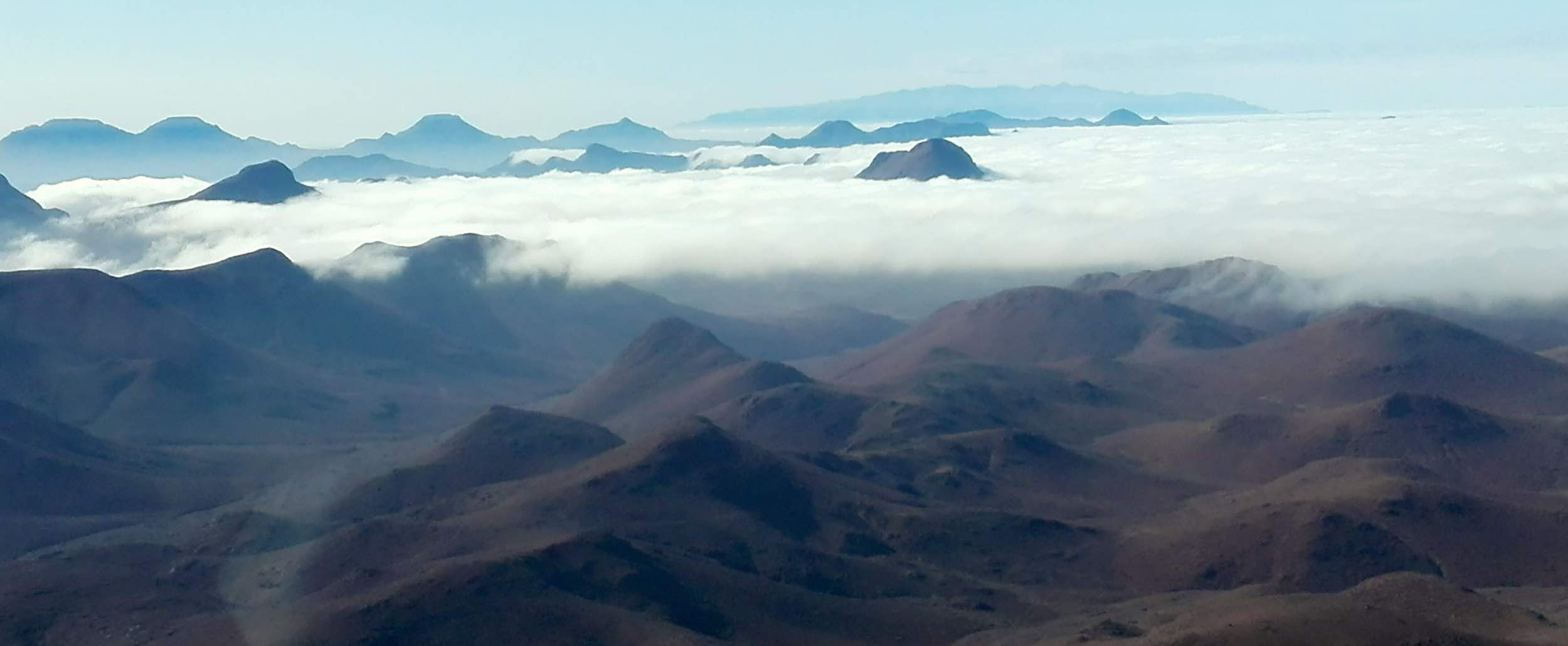 An aerial view of clouds hanging low over a mountain range in Namibia.