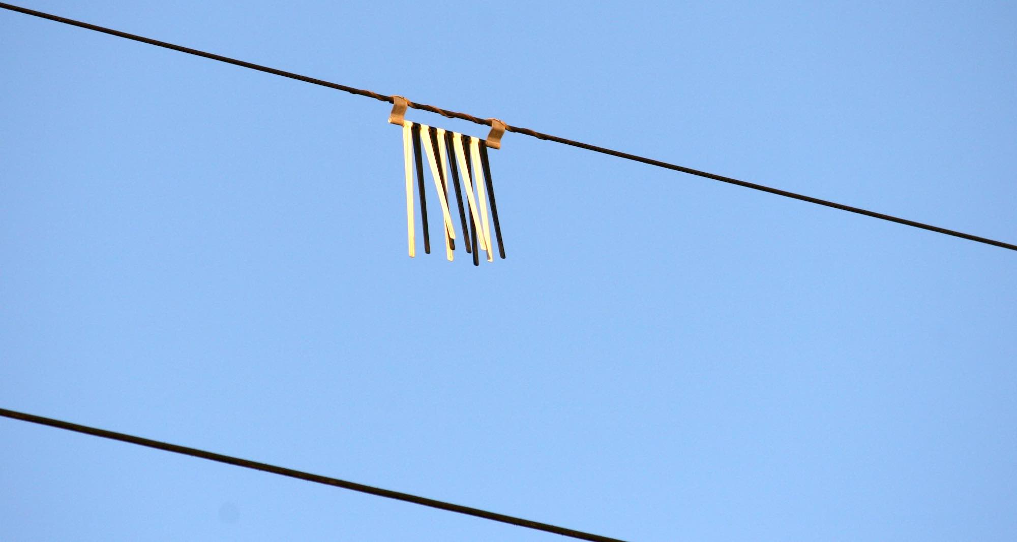 Hanging device that flaps in thw wind, attached to a power cable.