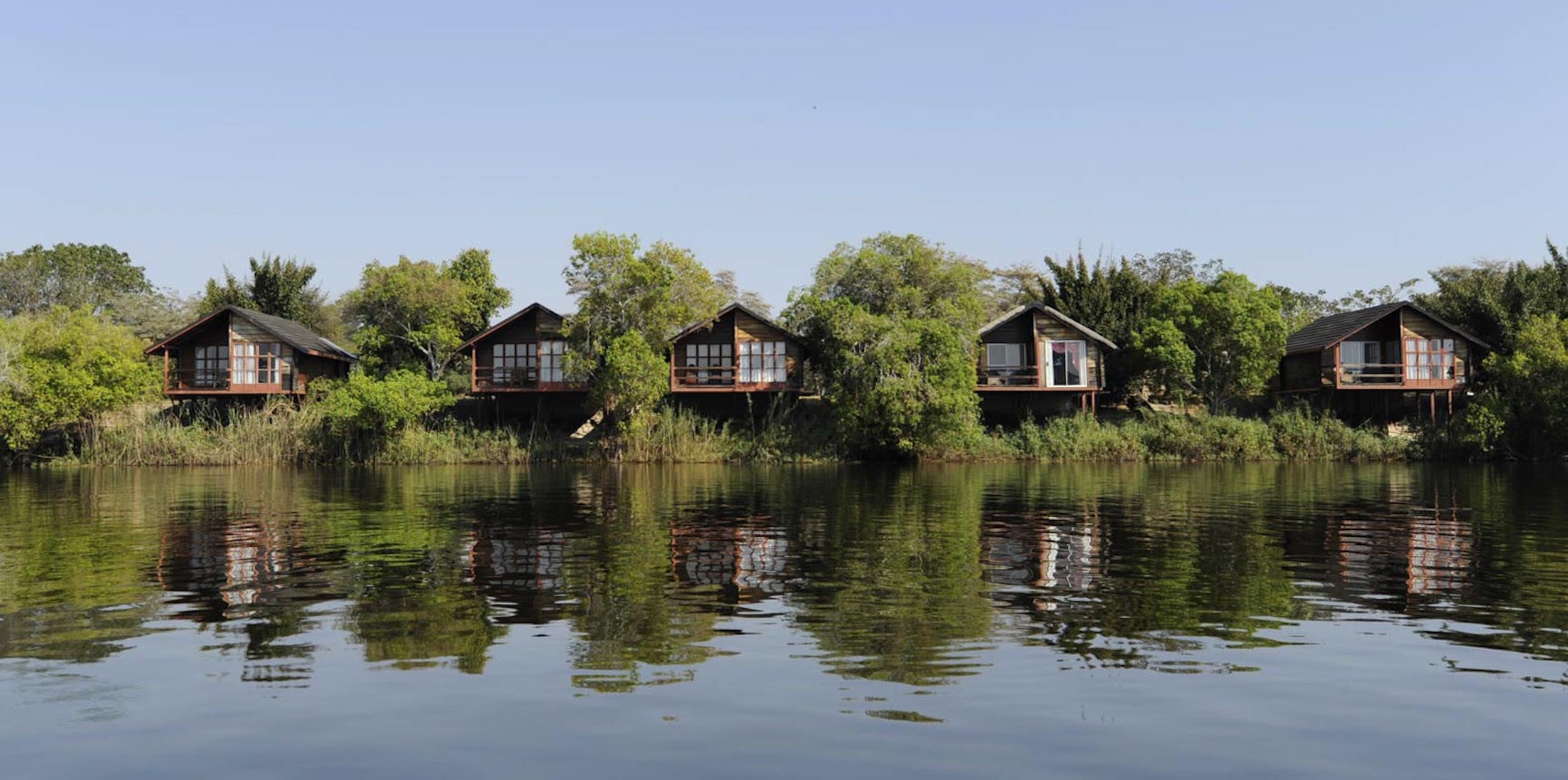 Luxury chalets peer out from amongst lush greenery overlooking the river.