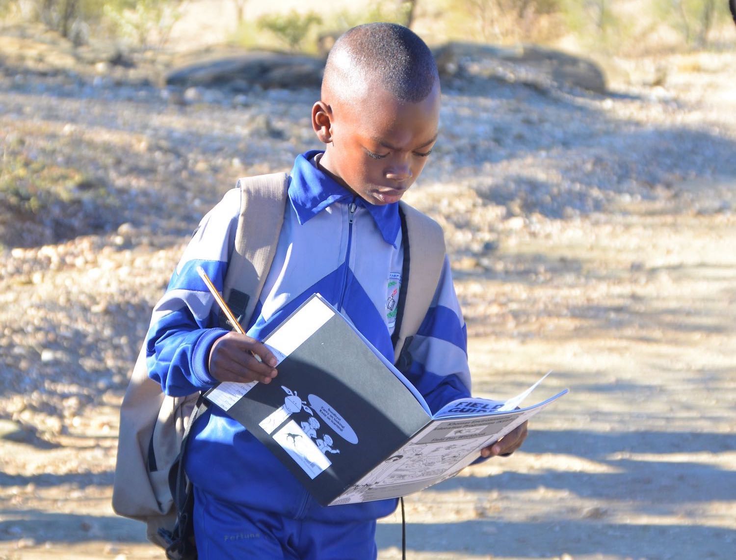 A young learner looks intently at his KEEP notebook.