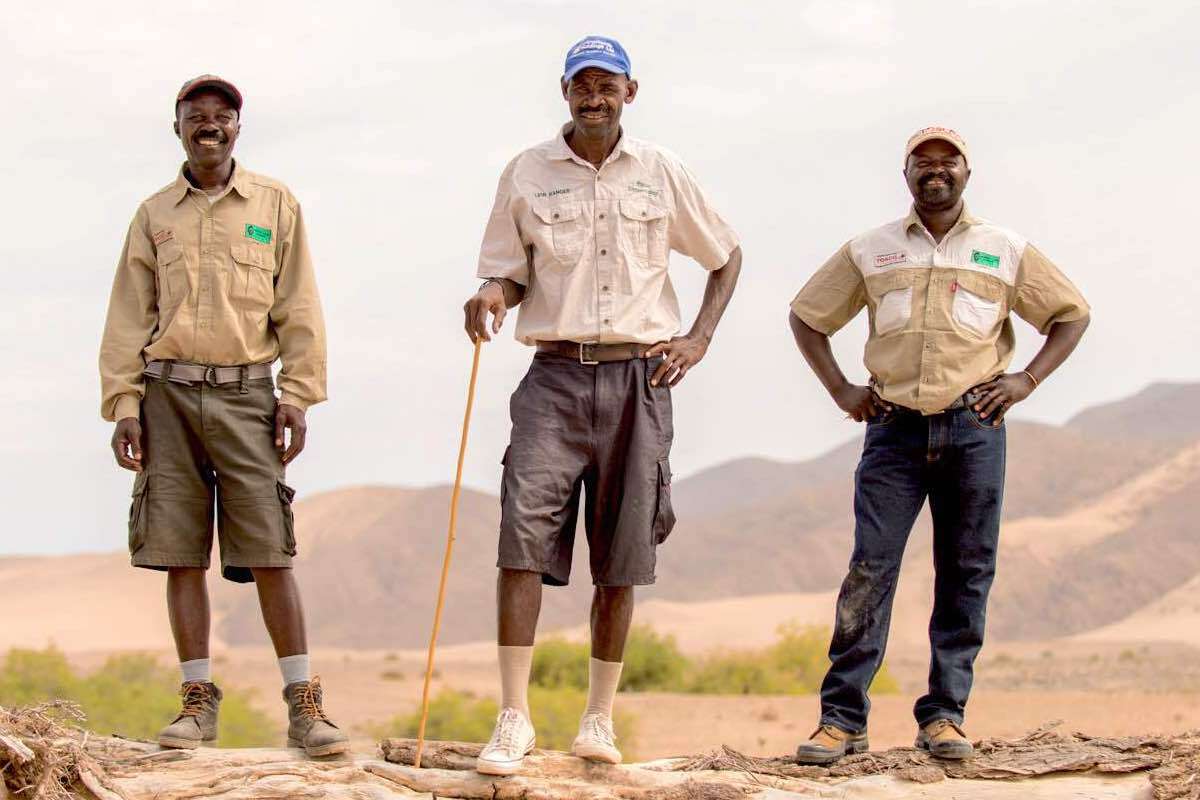 Three Namibian game rangers standing facing the camera.