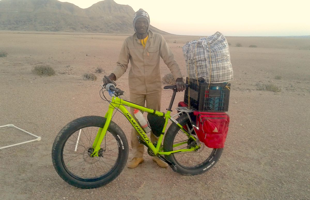 The author stands next to a lime-green fatbike loaded with supplies.