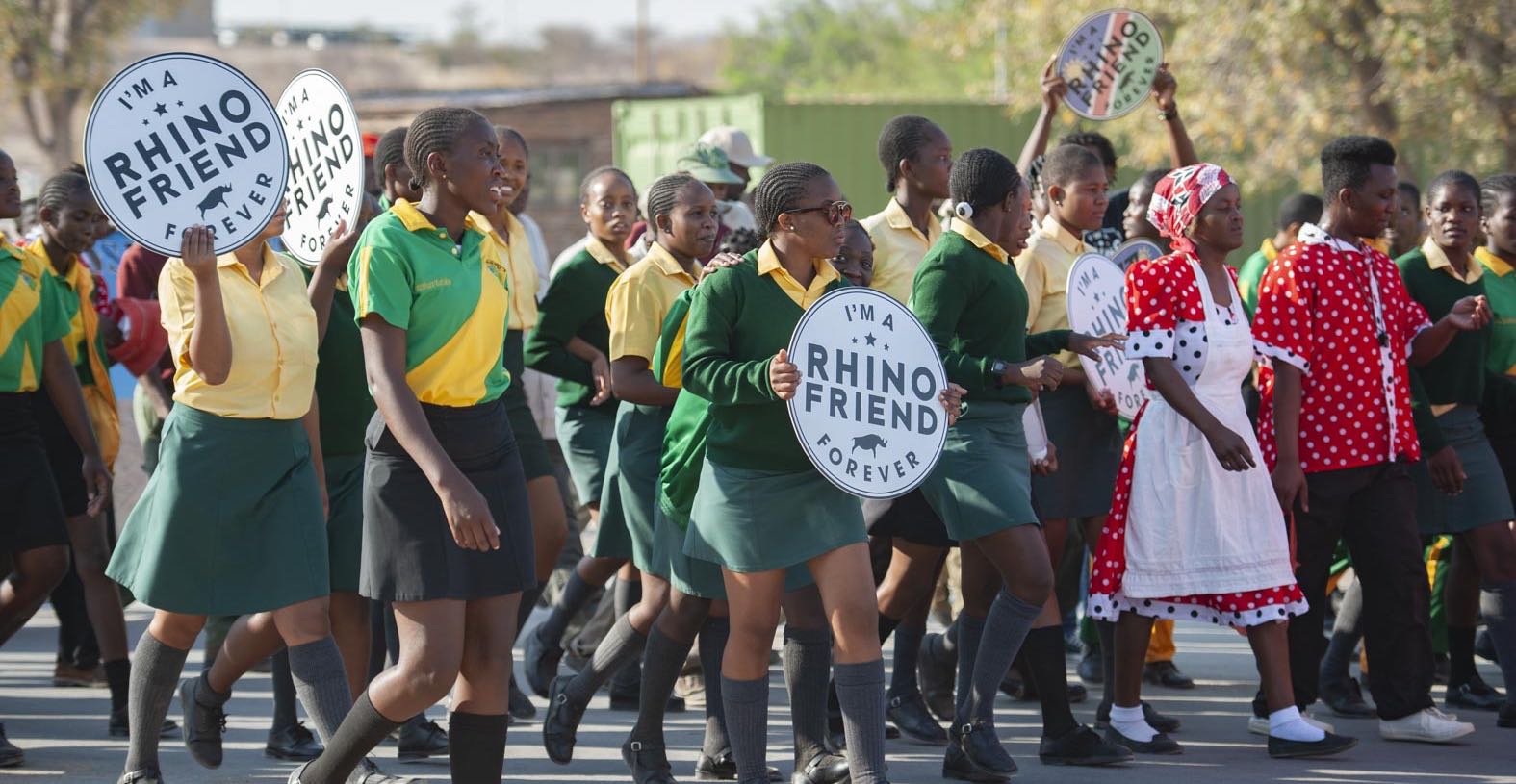 A group of Namibian schoolchildren carrying placards that read: I'm a rhino friend forever.