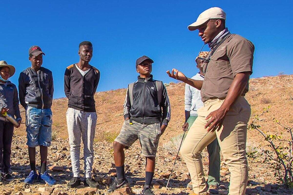 A group of Namibian children listen to their guide.