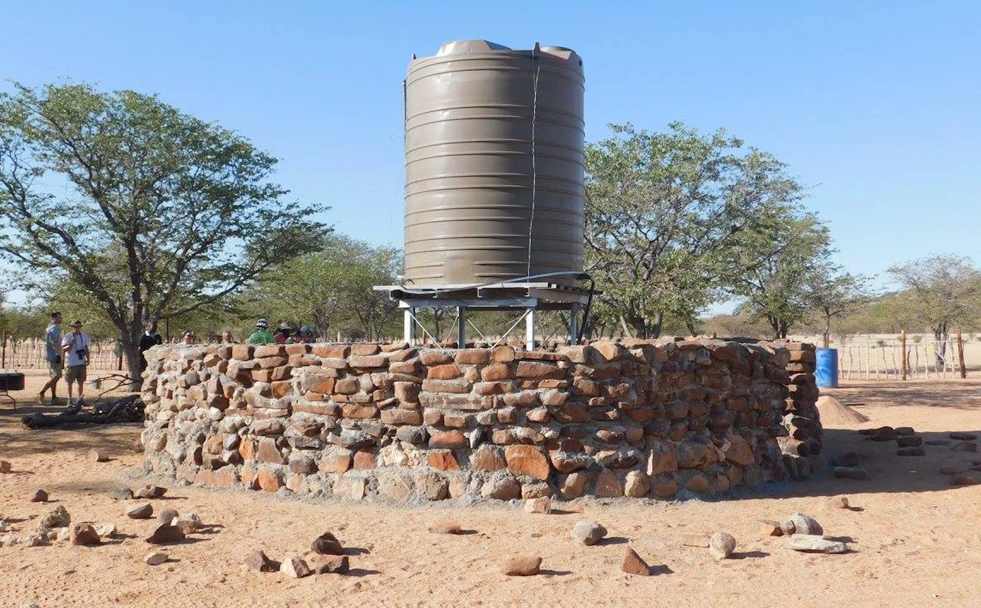 A water tank surrounded by a thick stone wall cemented together.