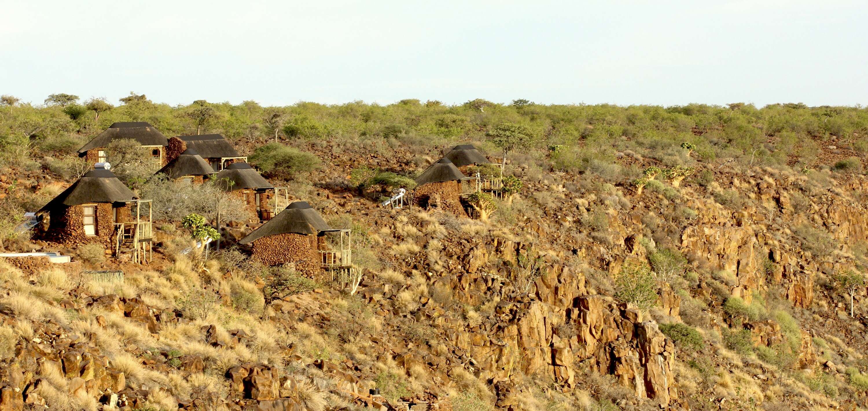 Red stone cabins dotted across a mountain top.