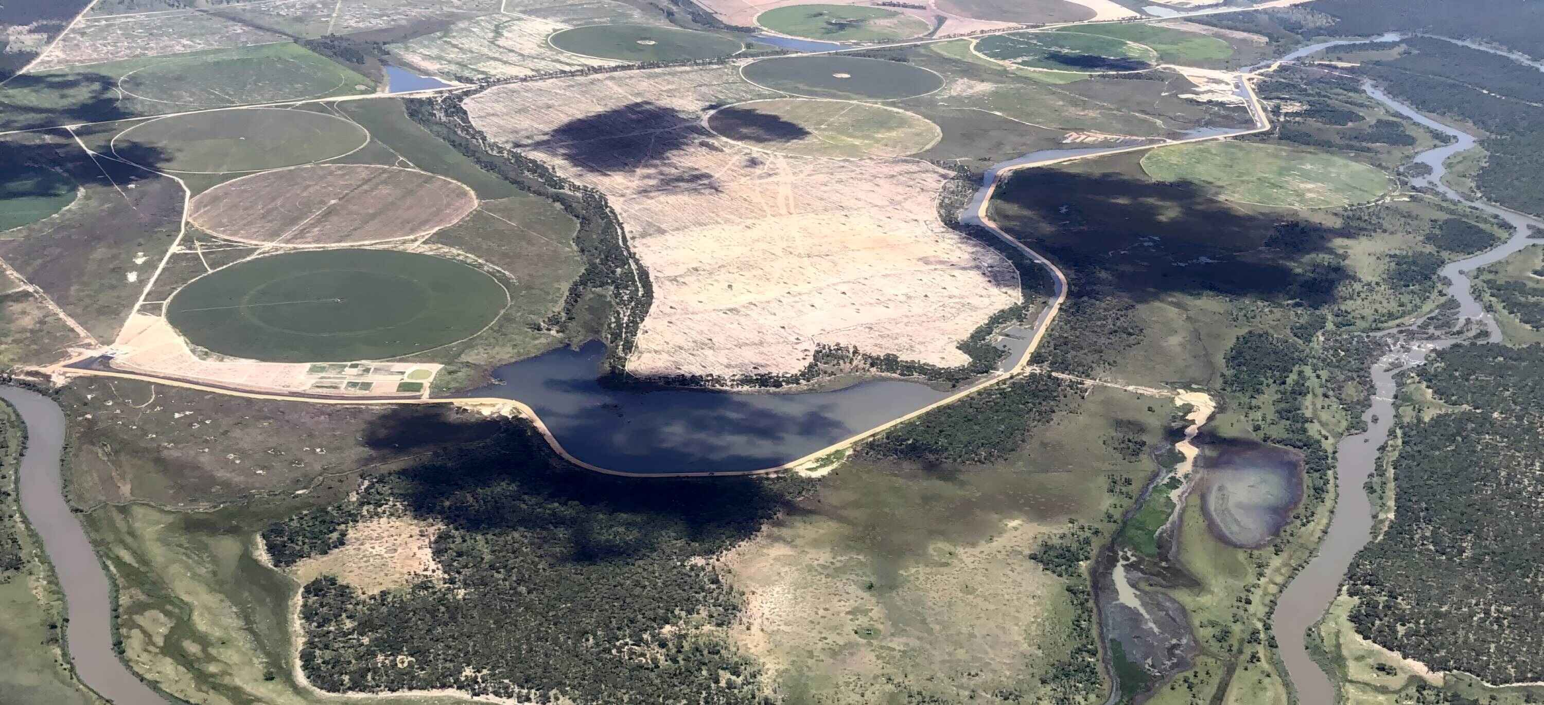 Aerial view of farms encircled by a curve in the river.