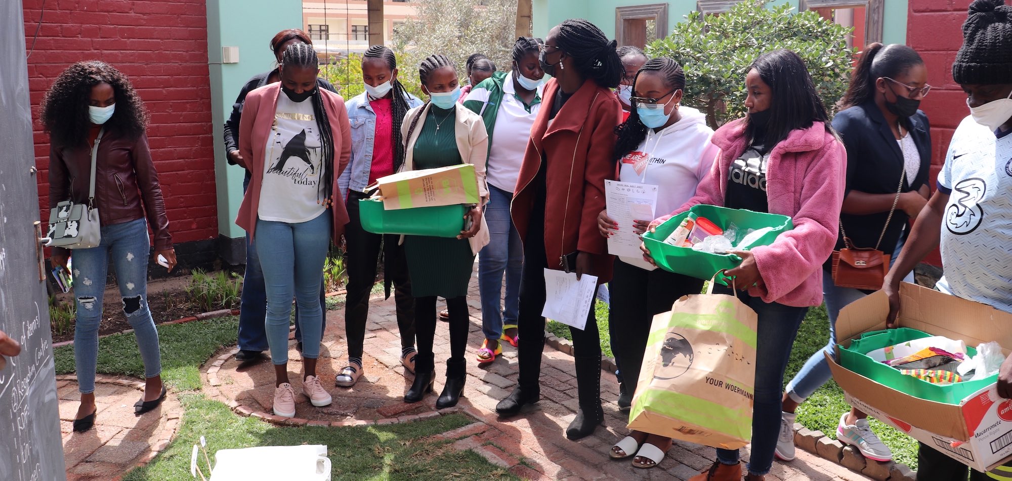 A group of people hold boxes containing environmentally friendly meals.