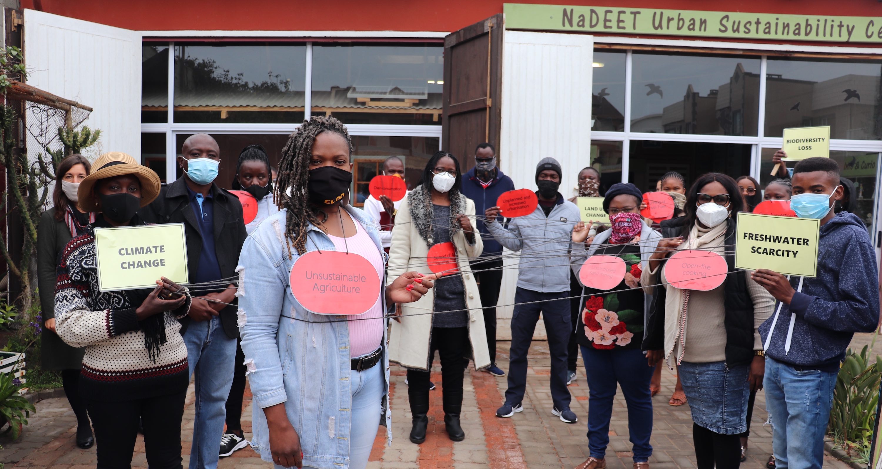 A group of participants holding string and signs representing the wicked web.