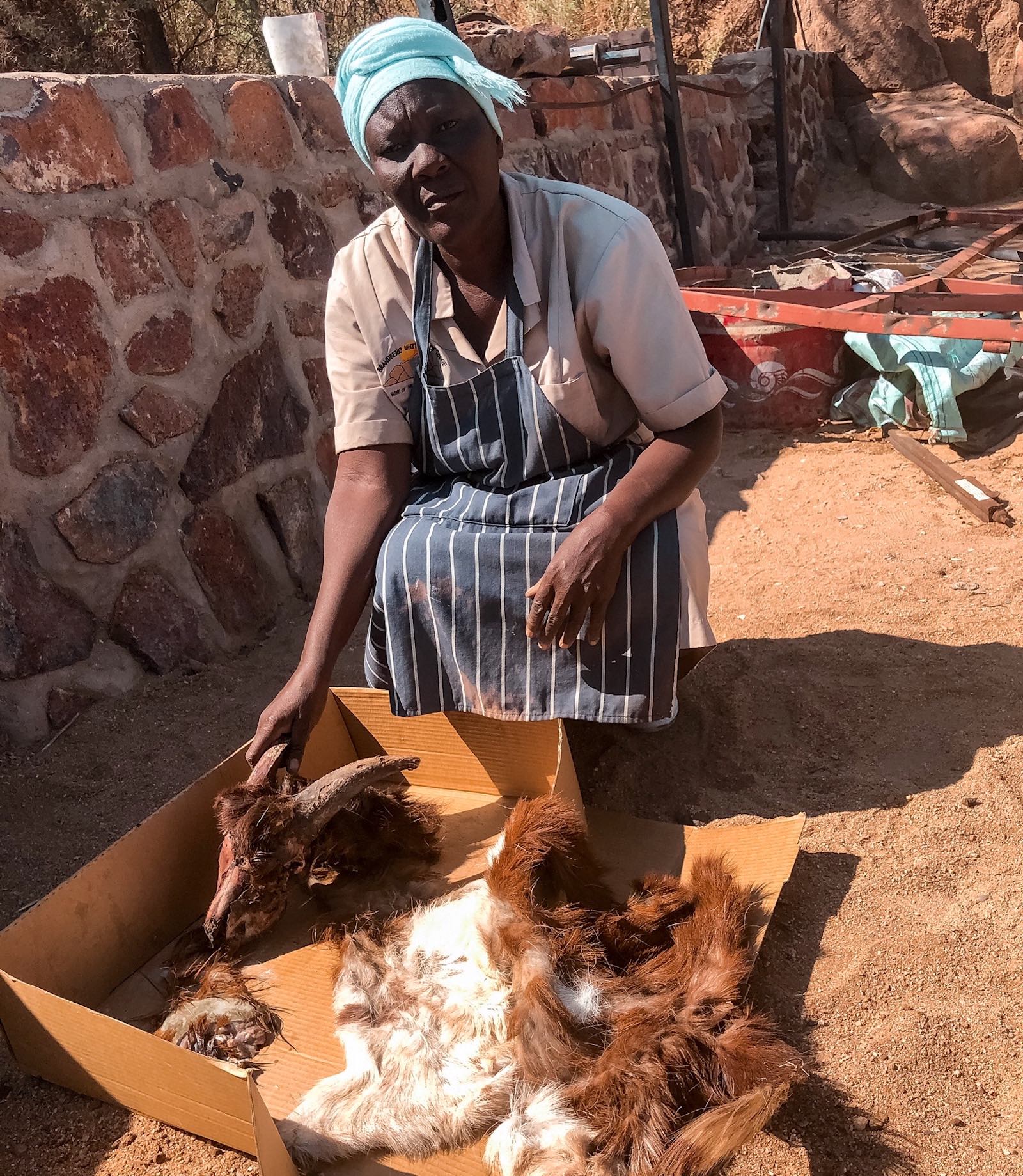 A woman with the carcass of a goat in a cardboard box.