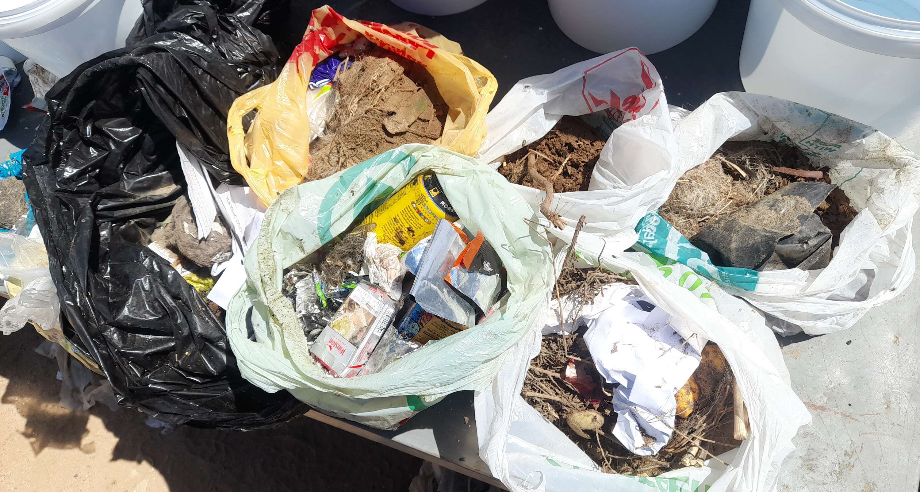 Looking down on the high plastic content of several black rubbish sacks.