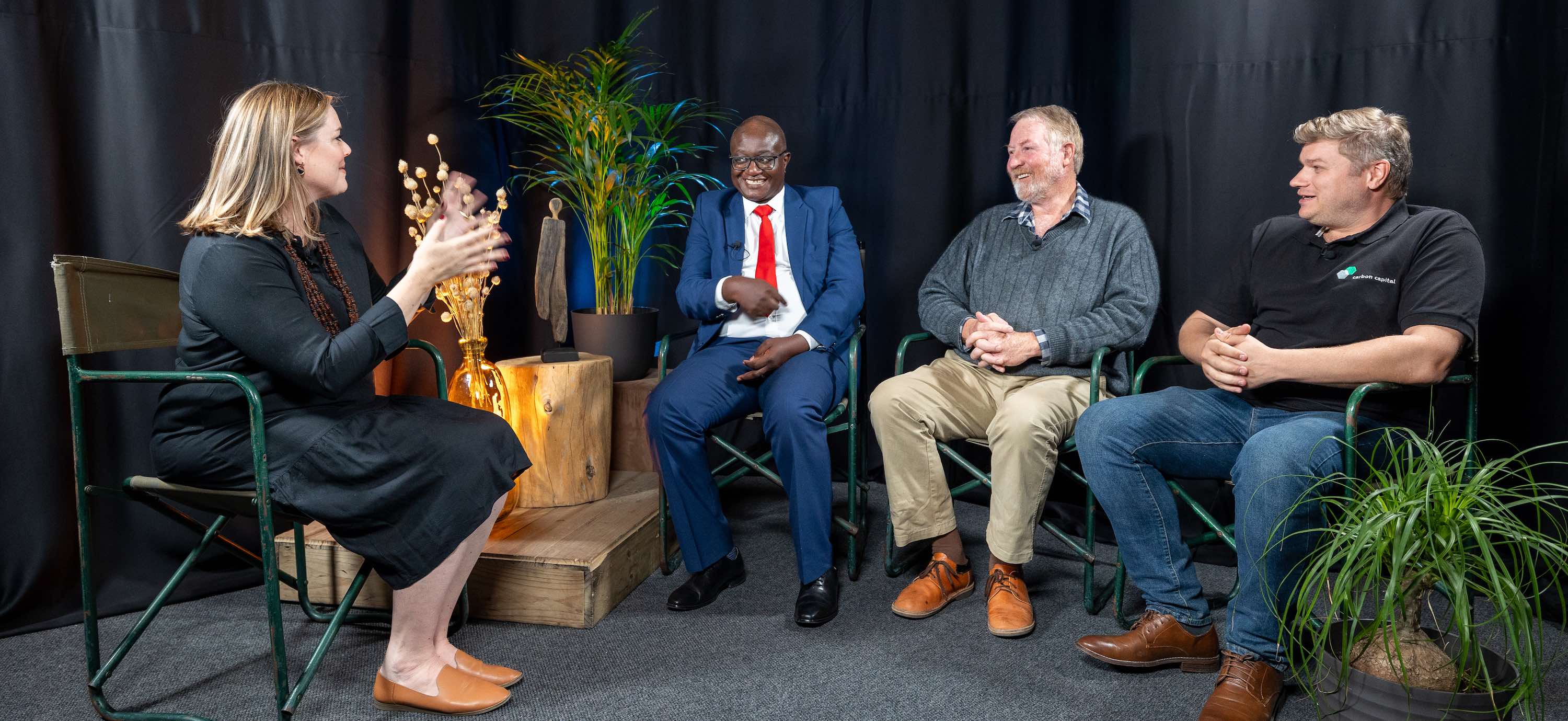 A panel discussion - a woman interviews three men.