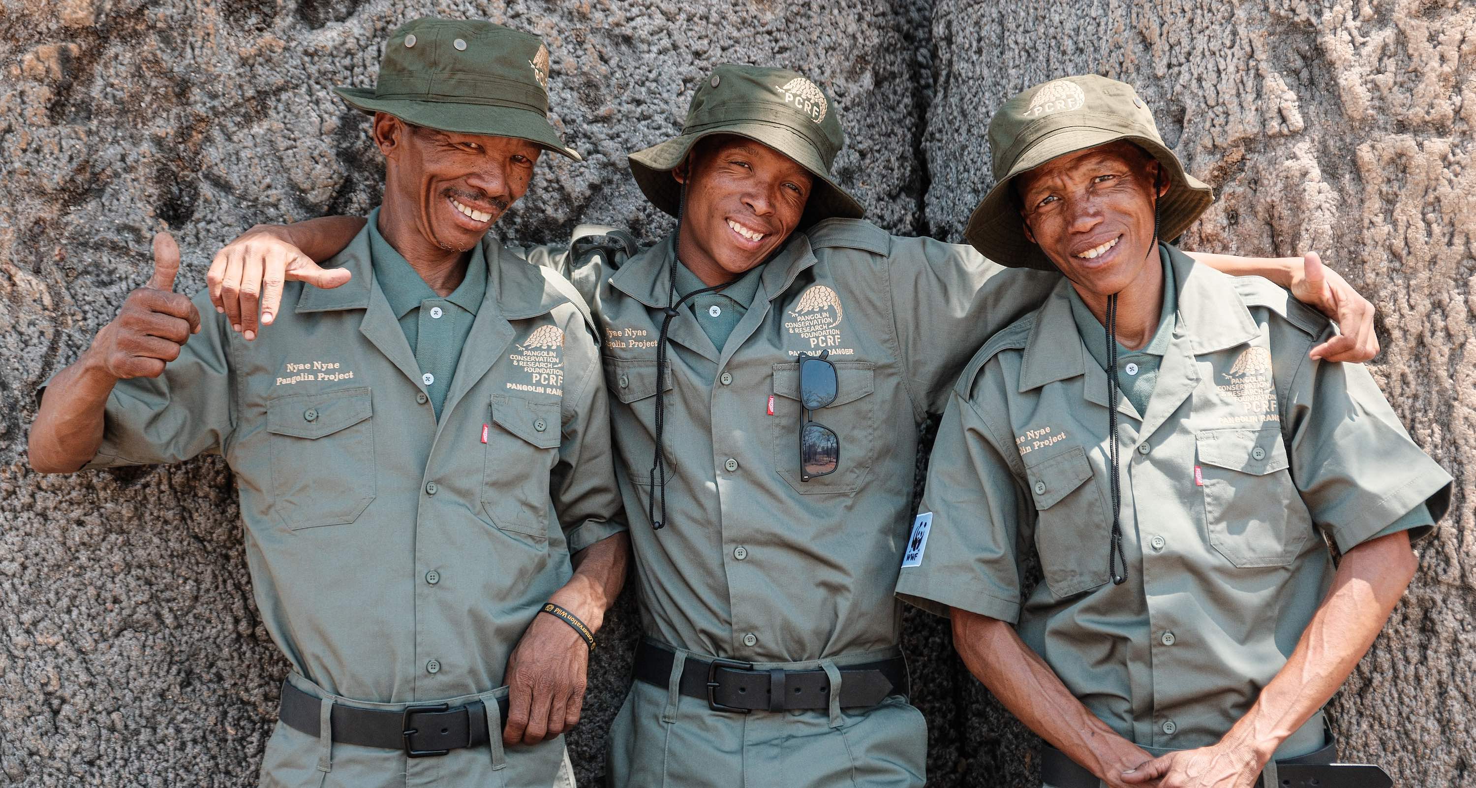 Three uniformed rangers smiling at the camera.