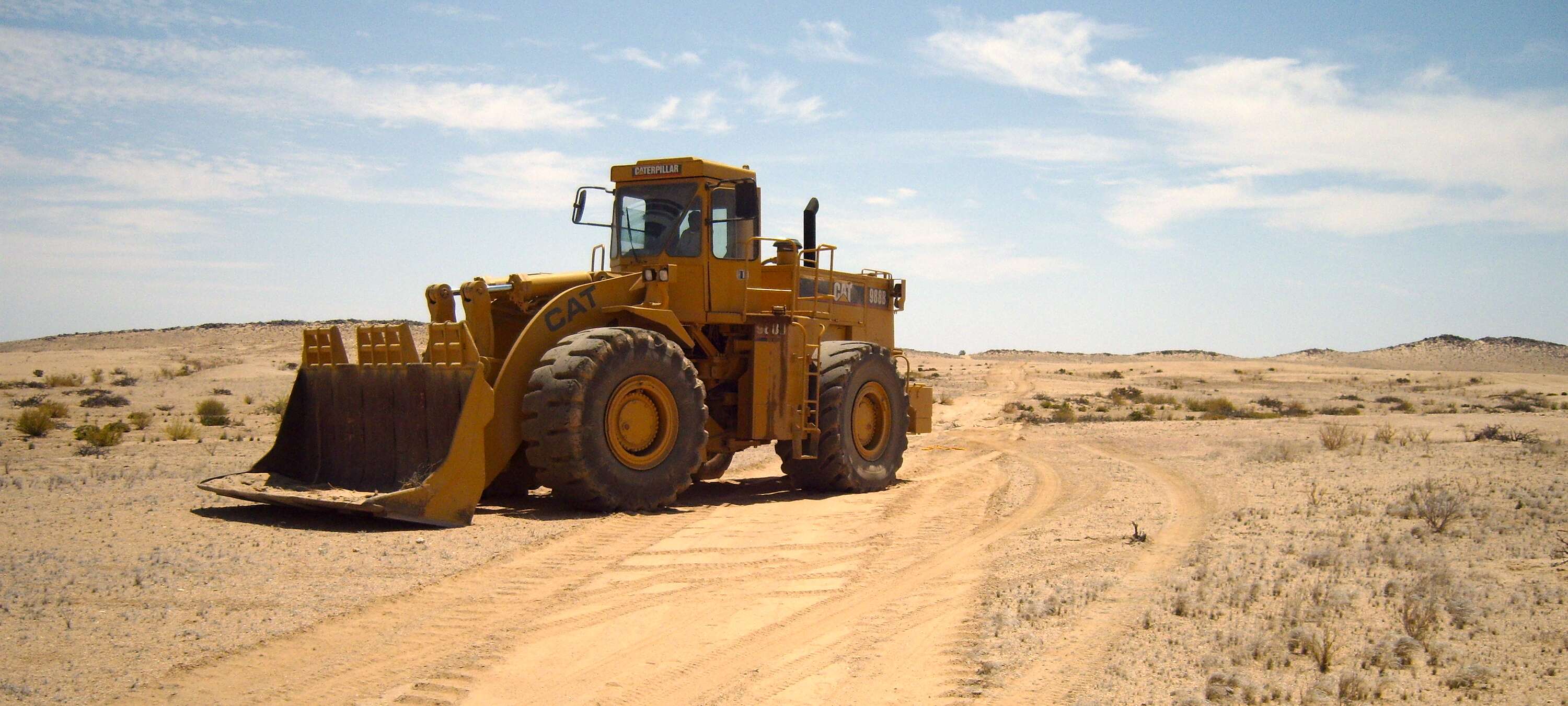 A large mechanical digger parked in the desert.