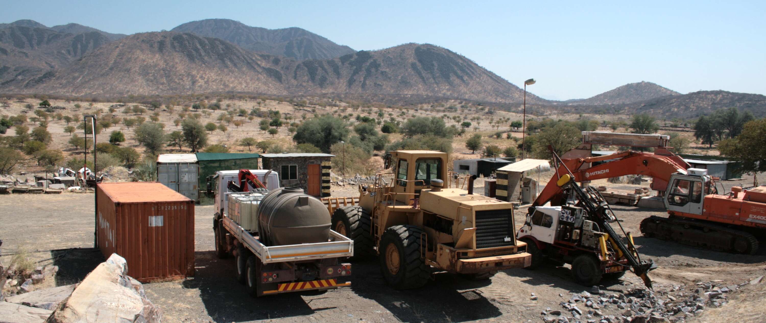 A line of assorted mechanical equipment against a desert and mountainous backdrop..