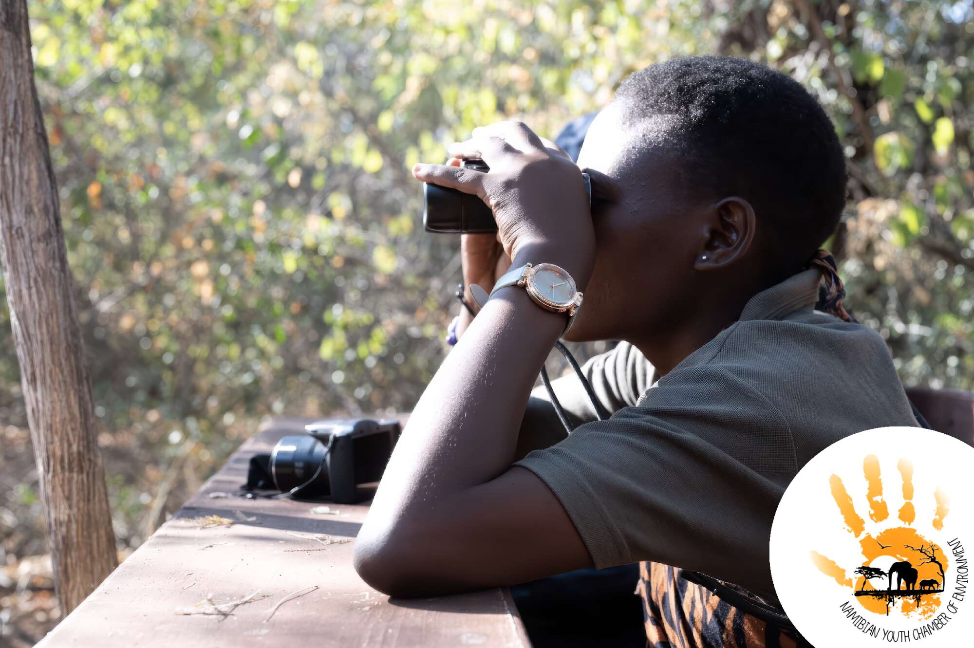 Close-up profile of a woman looking through binoculars.