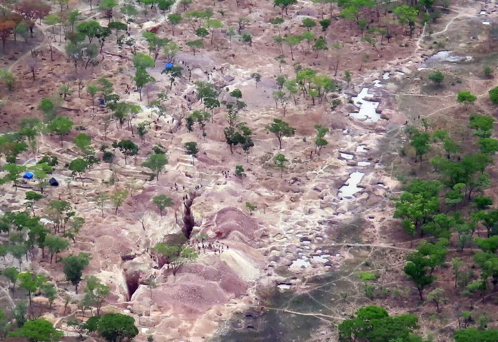 A bleak rocky area with groups of people at work.