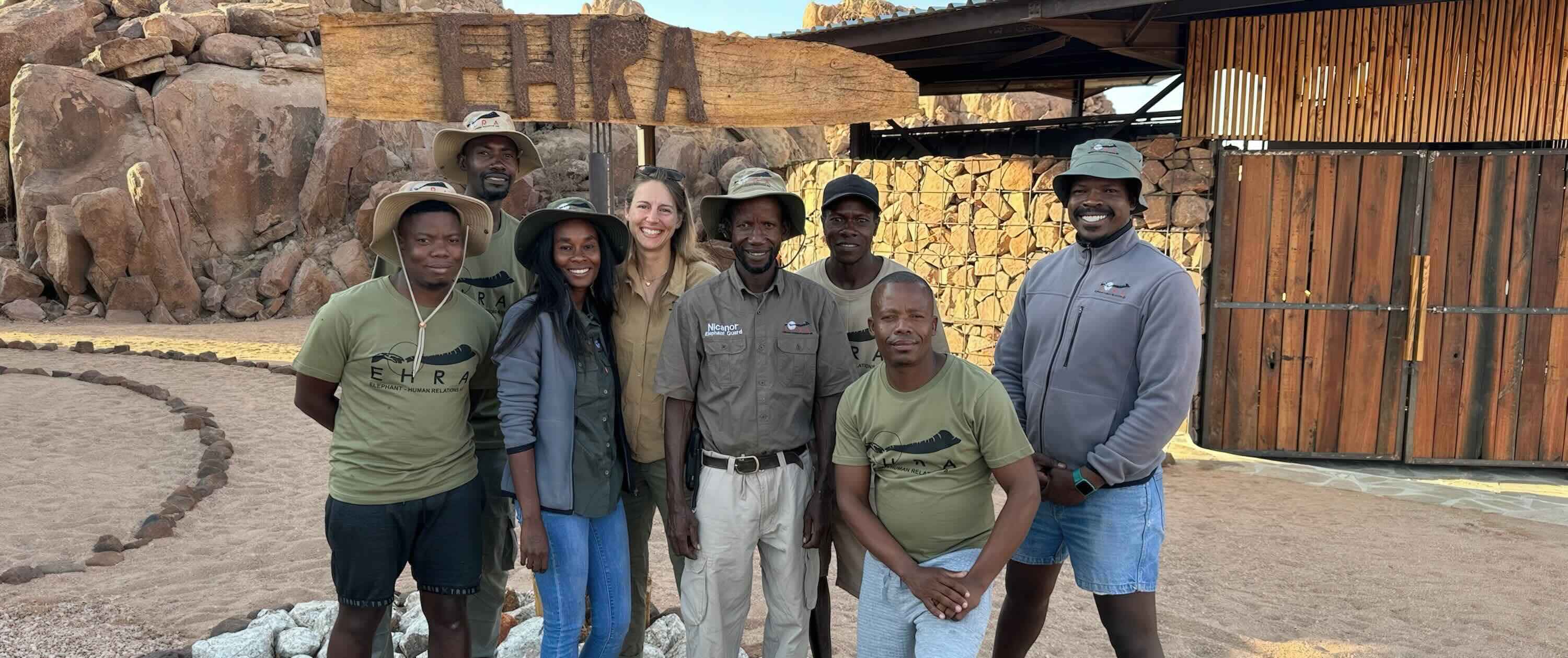 Eight people pose for the camera.