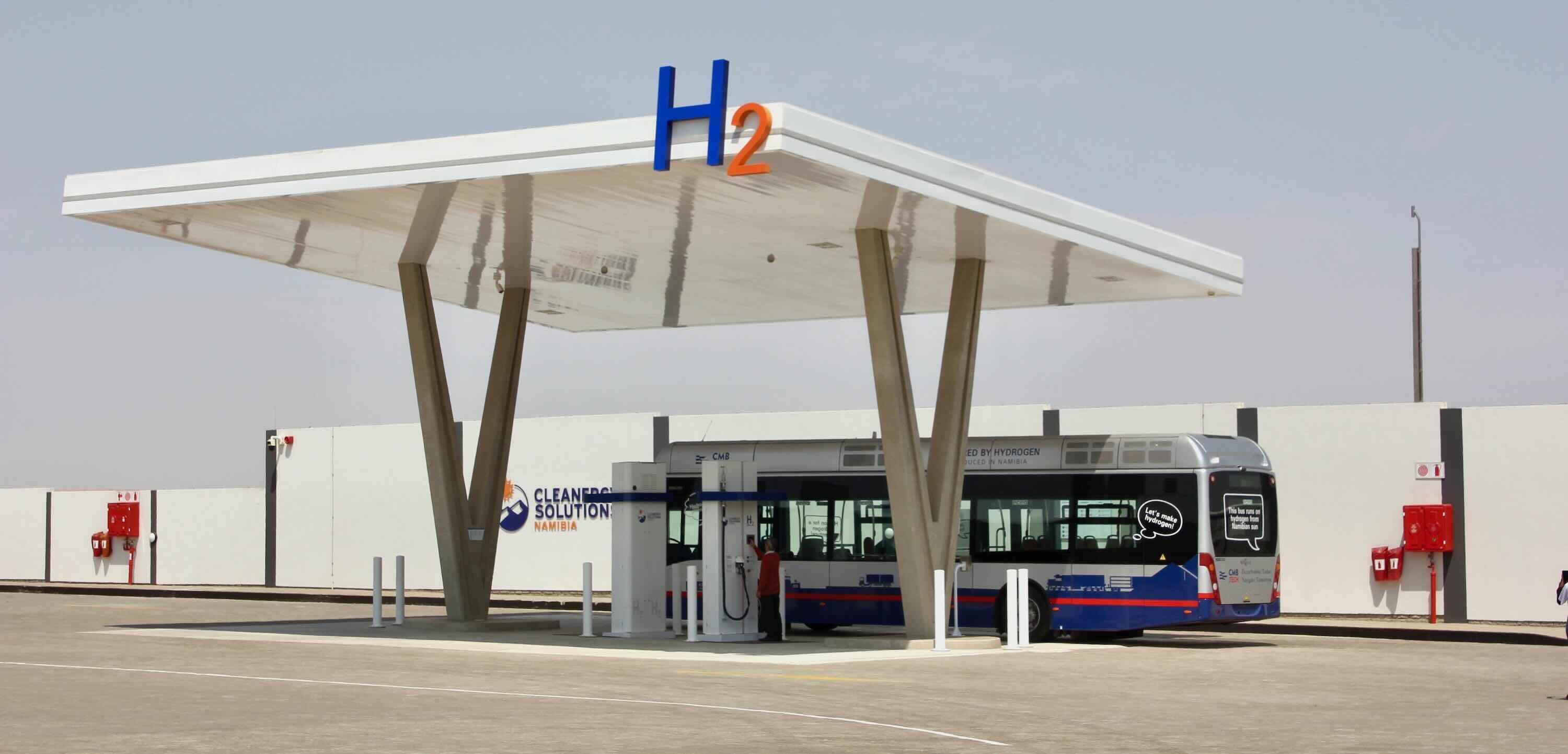 A new looking fuel station with a bus getting ready to refuel.