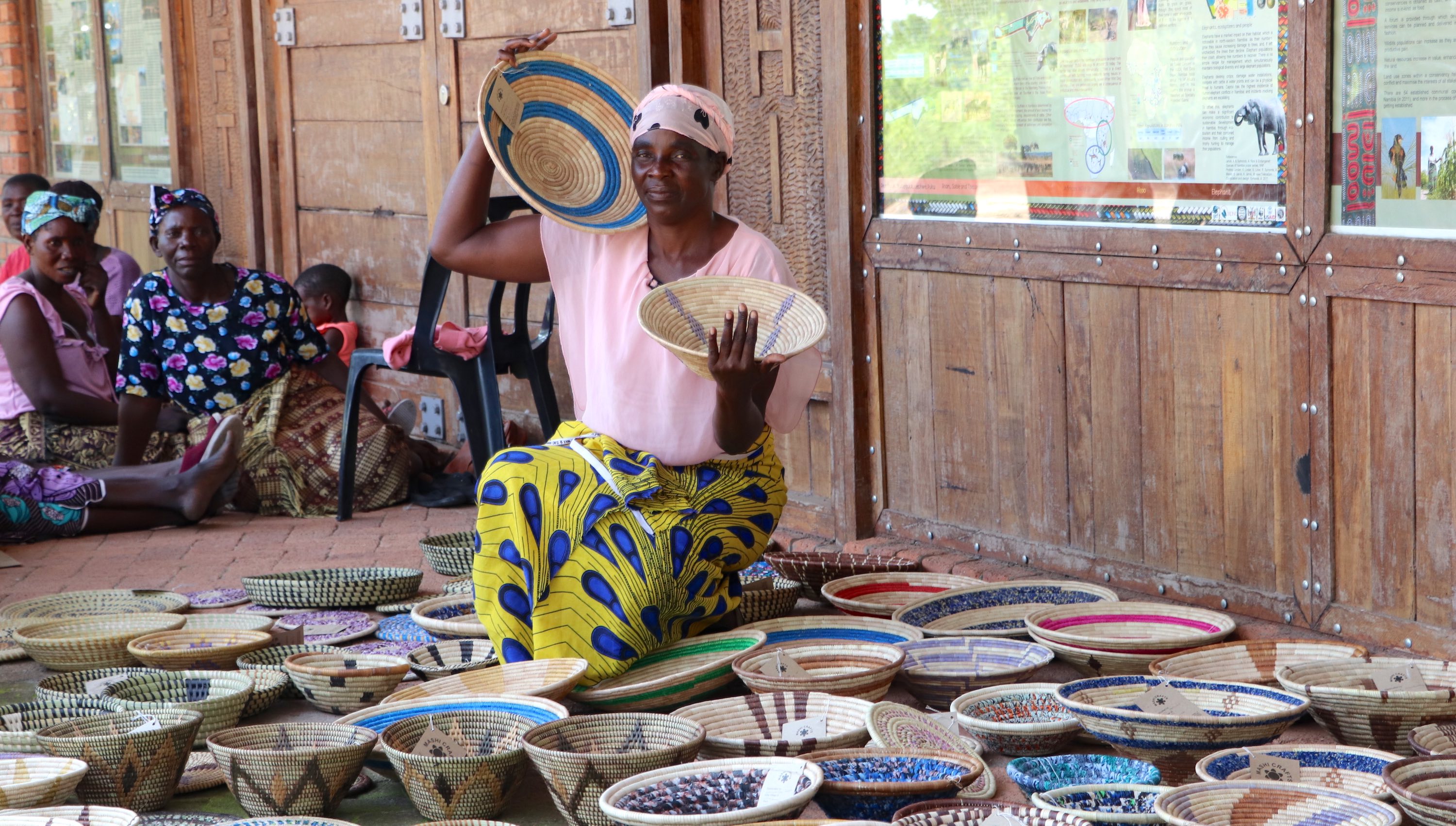A woman poses with a collection of home-made baskets.