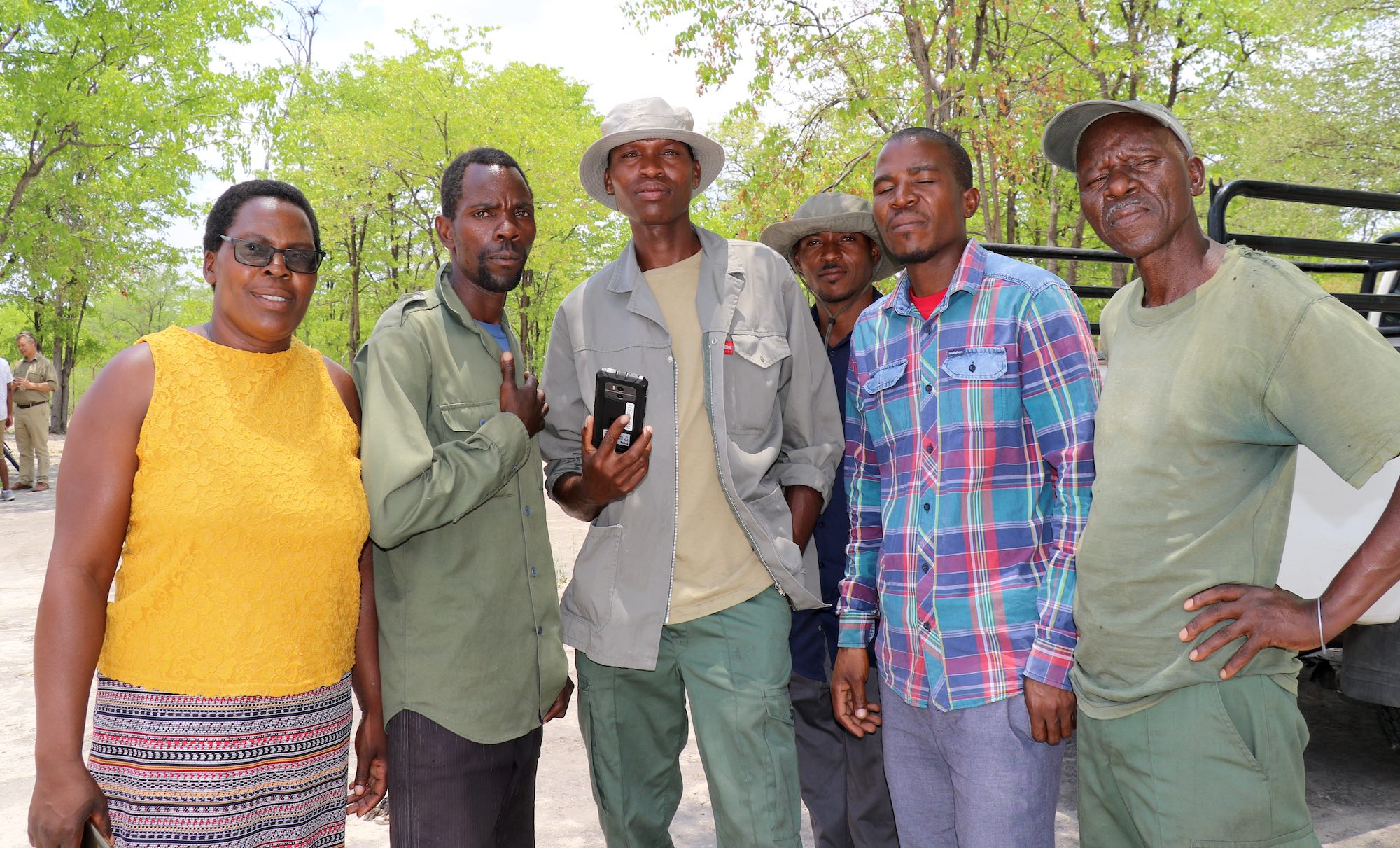 A group of community members pose with a smartphone.