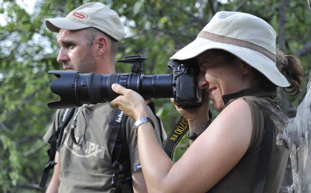 A woman looks through her high-powered camera.