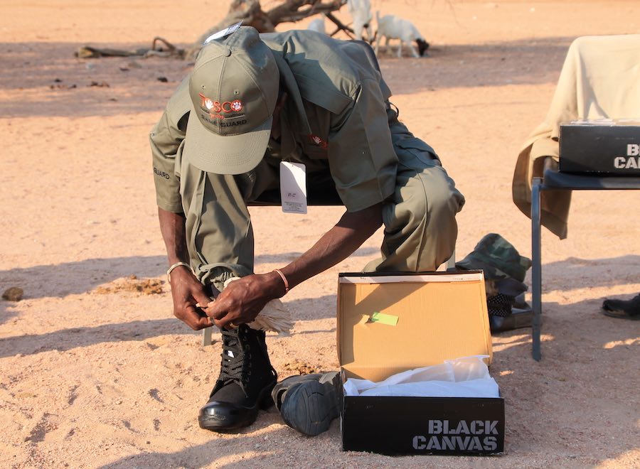 A community game guard tries on a new pair of boots.