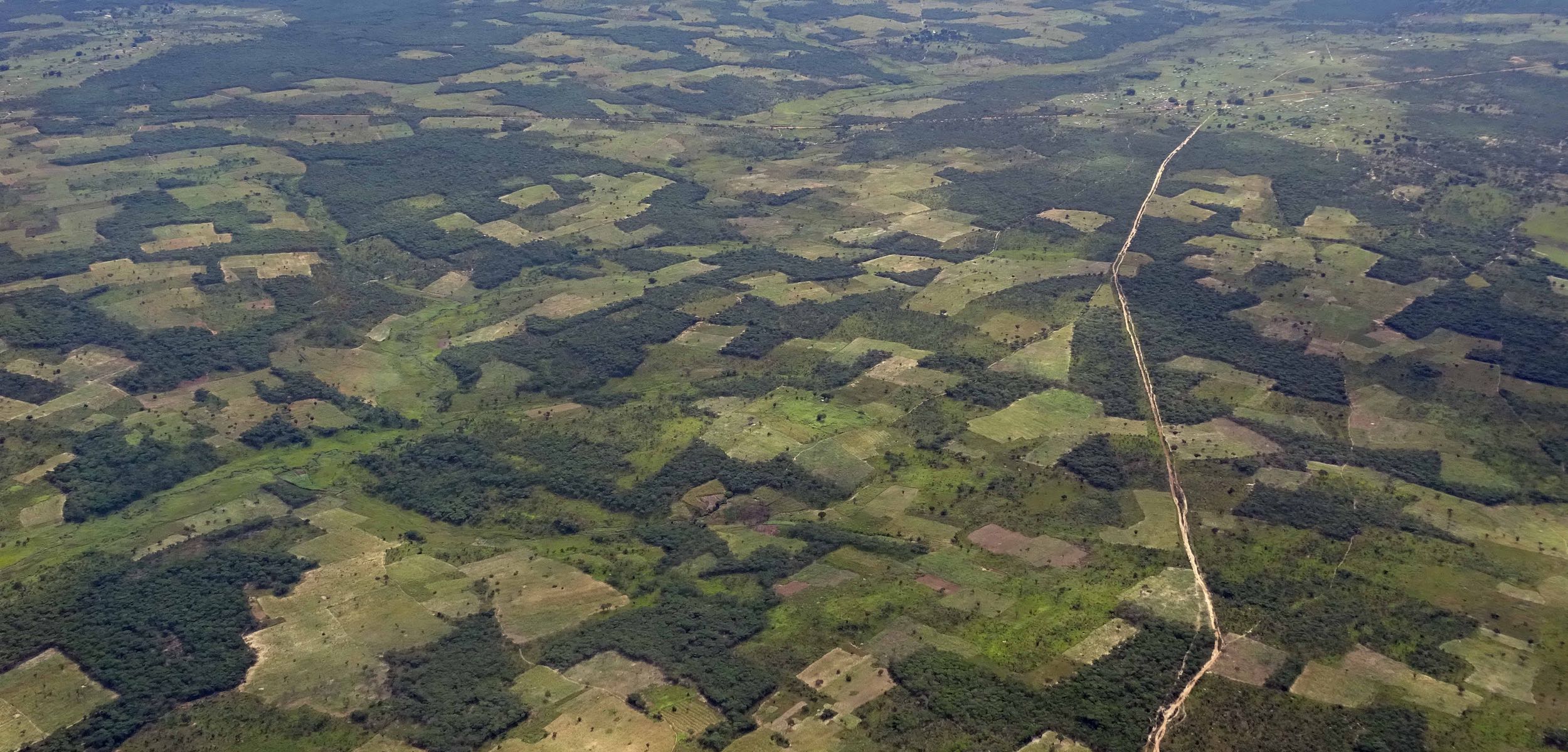 An aerial view of rural Africa showing uneven patches of fields and bush.