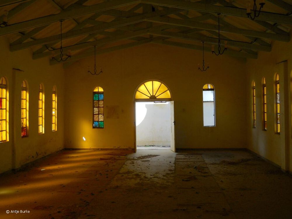 Golden light filters through the remaining windows into the interior of this long-abandoned chapel.