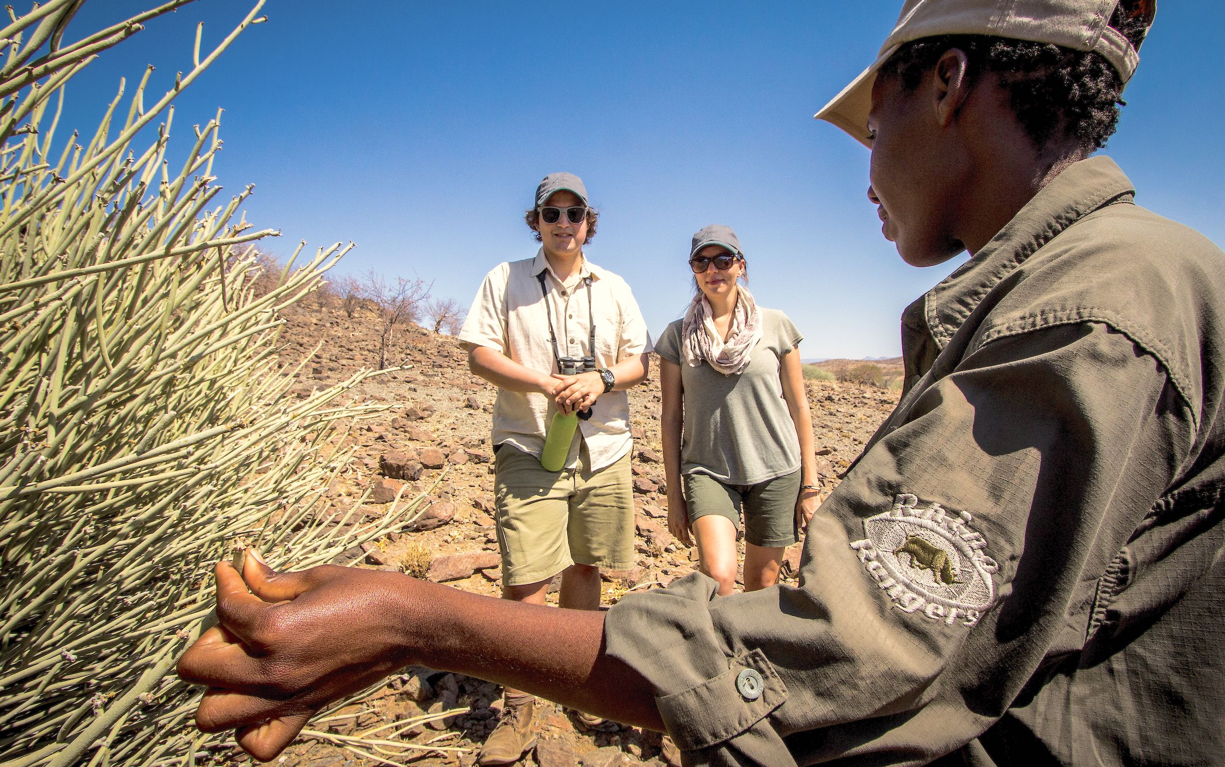 A Namibian rhino ranger escorting two tourists.