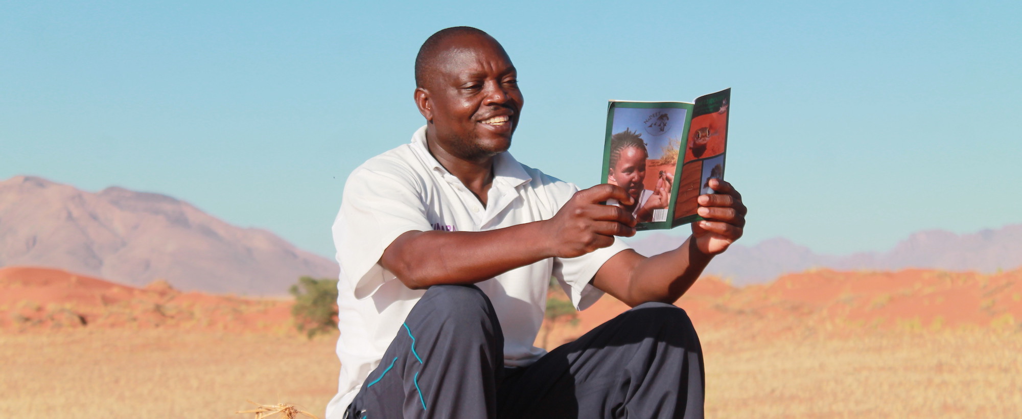 A Namibian man studies an educational booklet.