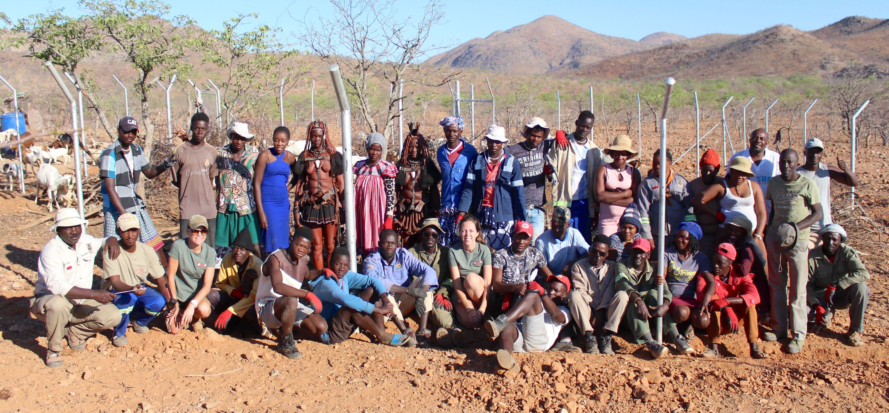 Members of the TOSCO team pose with local community members in front of a new predator-proof kraal.
